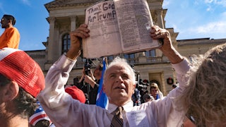 A preacher holds up his Bible while supporters of Donald Trump host a 'Stop the Steal' protest outside of the Georgia State Capital building.