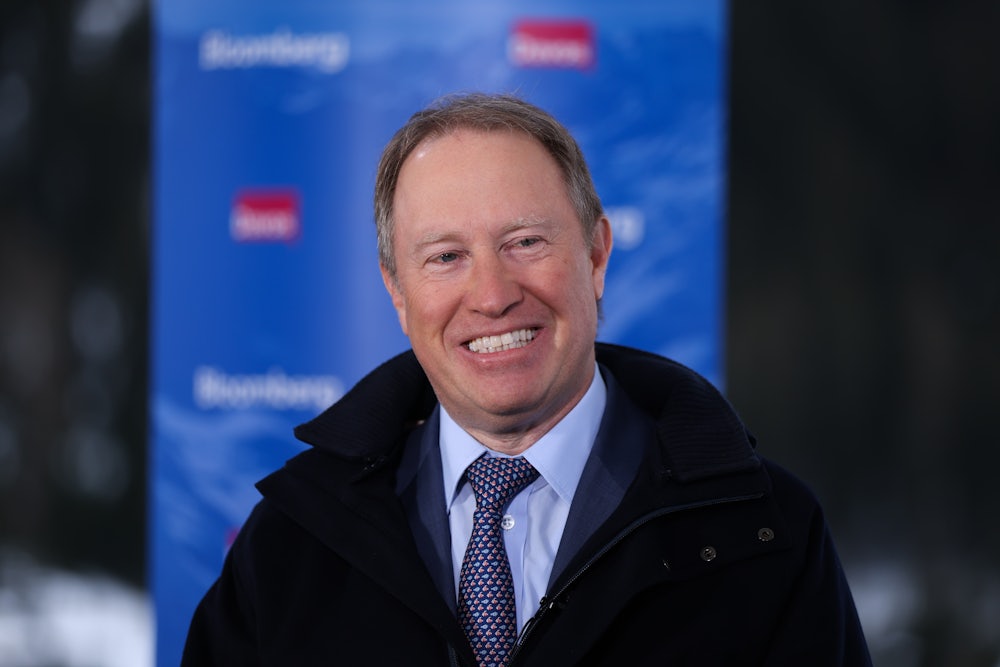 Ted Pick smiles while wearing a suit and a coat.