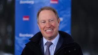 Ted Pick smiles while wearing a suit and a coat.