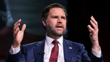 Vice President JD Vance raises his hands up while speaking