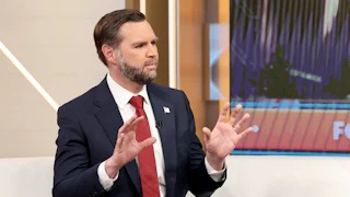 JD Vance holds up both hands while talking