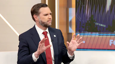 JD Vance holds up both hands while talking