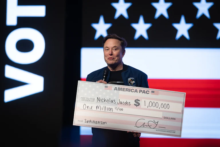 Elon Musk holds a massive $1,000,000 check.