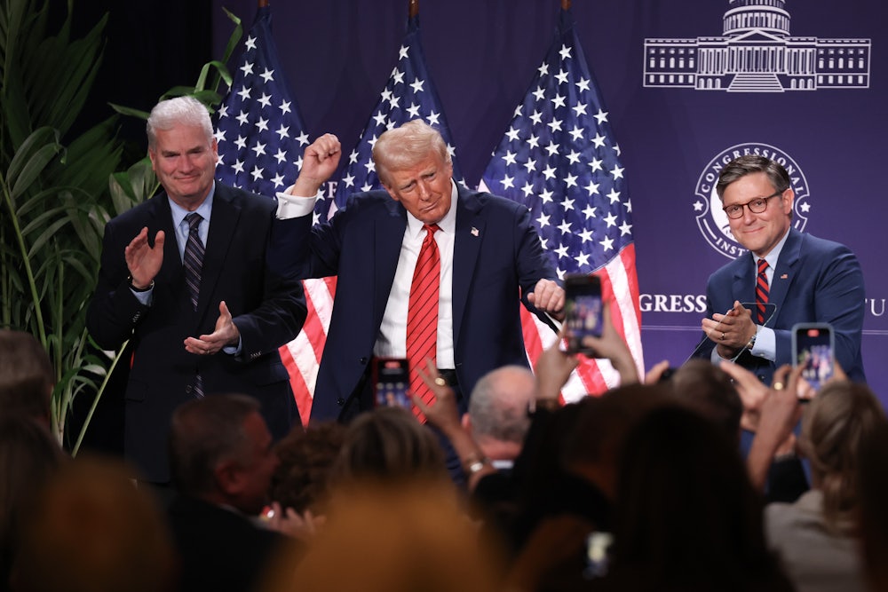 Trump holds his fists up, dancing in front of a crowd, flanked by Tom Emmer and Mike Johnson.
