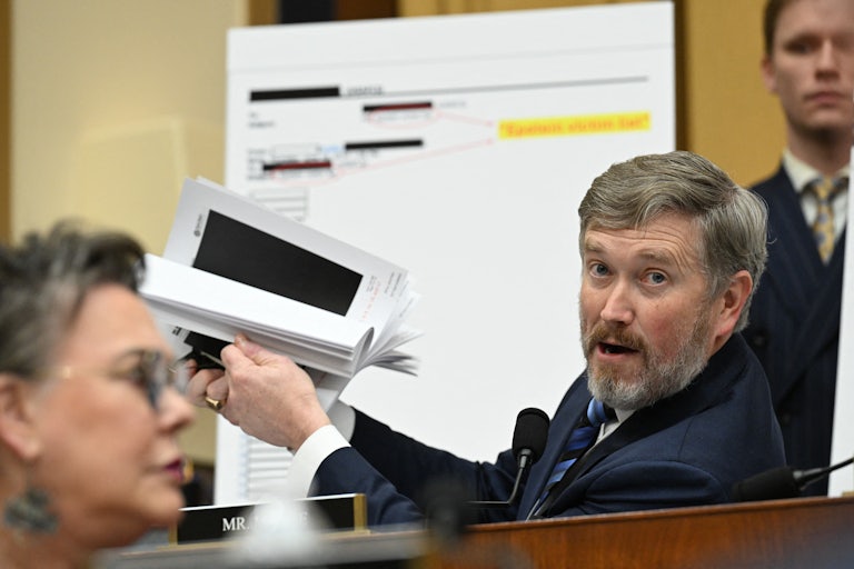 Massie holds up redacted documents in a House hearing.