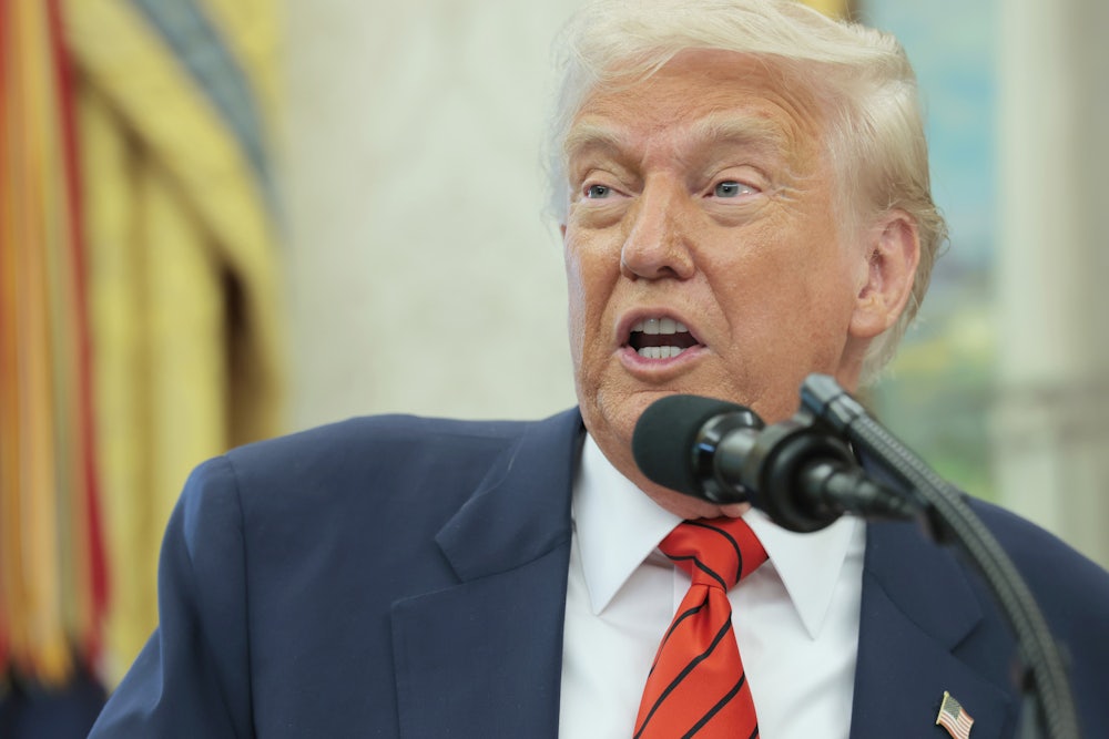 Donald Trump speaks into a microphone in the Oval Office