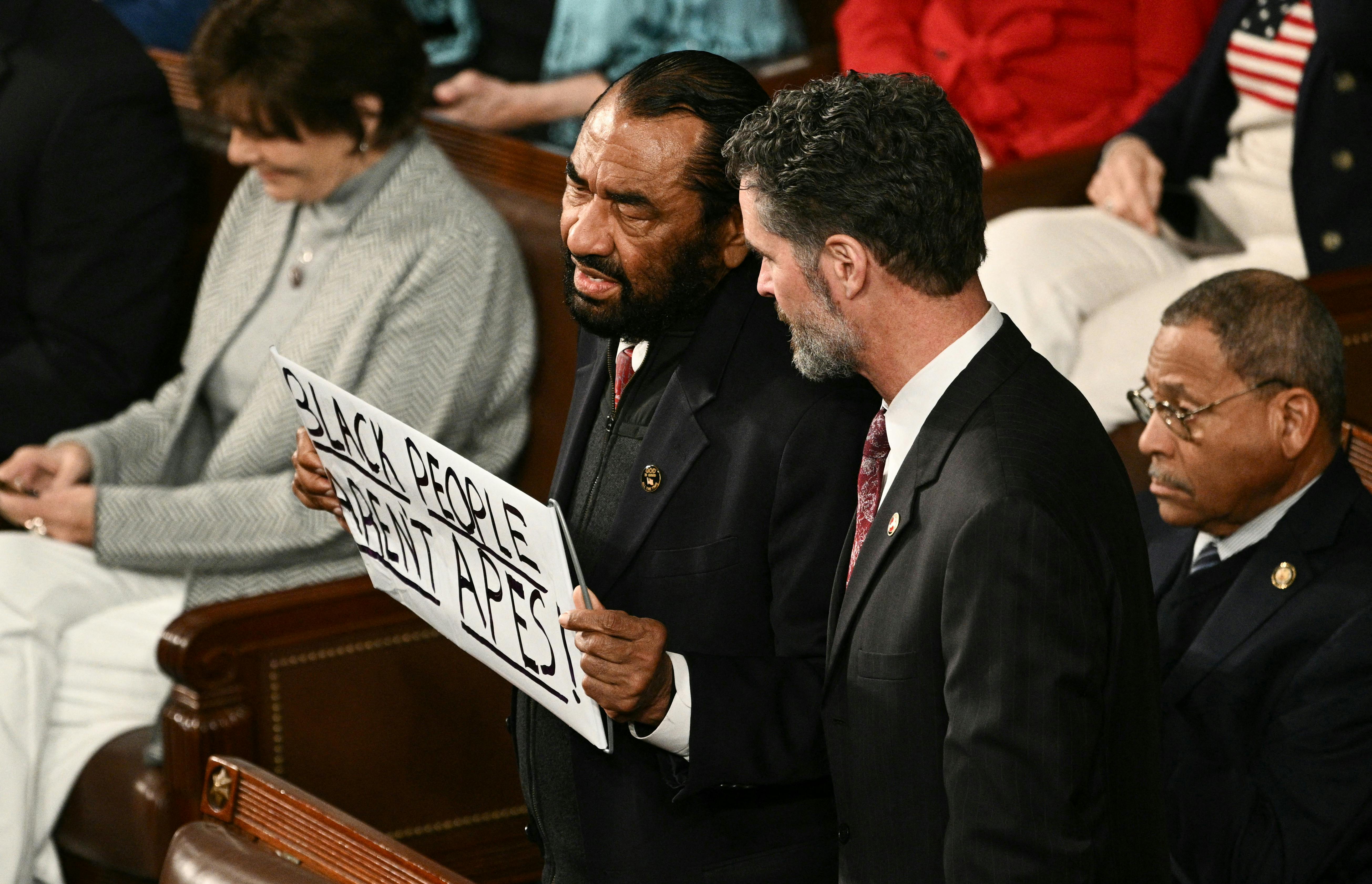 Representative Al Green holds a sign reading “Black People Aren’t Apes” during President Donald Trump’s State of the Union address.