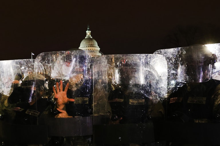 Members of the National Guard and the Washington D.C. police keep a small group of demonstrators away from the U.S. Capitol after a larger group stormed the building.