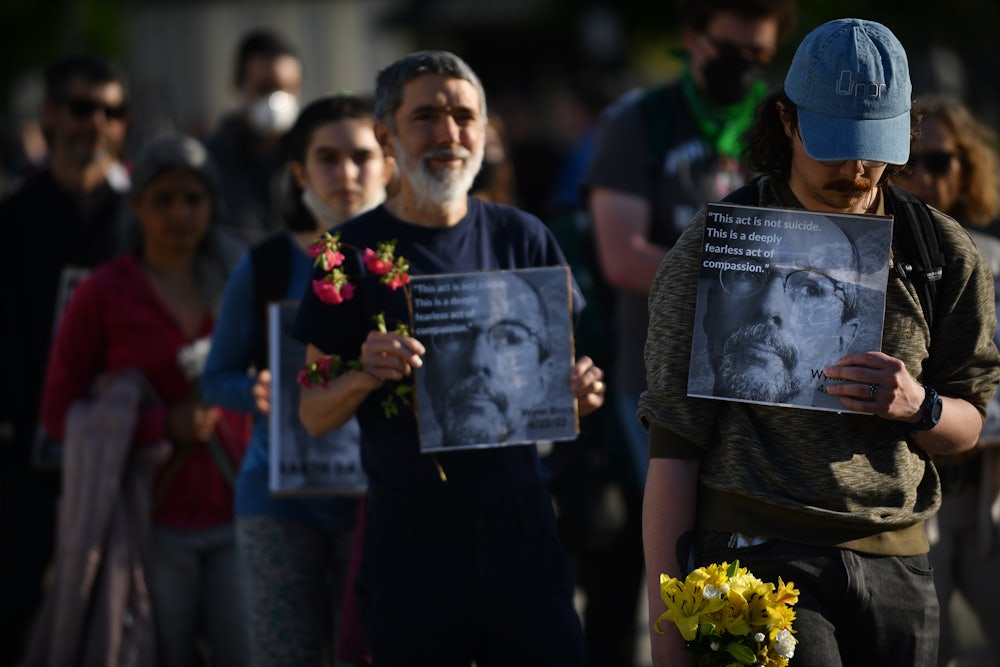 People hold signs with Wynn Bruce's picture.