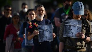 People hold signs with Wynn Bruce's picture.