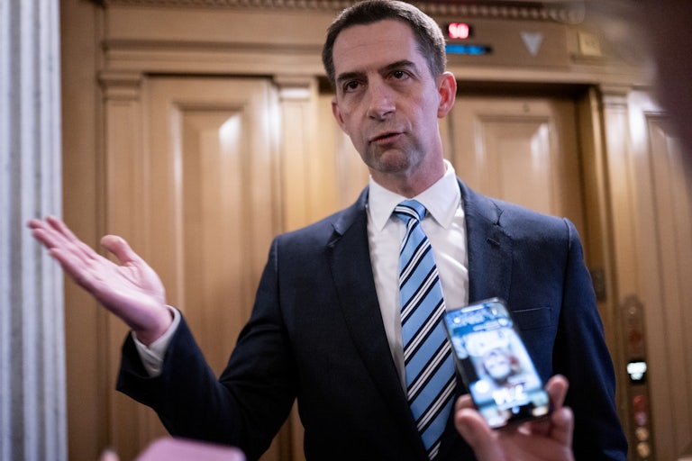Tom Cotton speaks and purses his lips. Reporters (off camera) likely surround him.