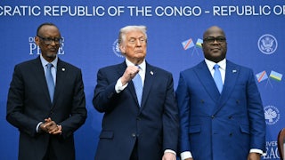 Donald Trump raises his fist while standing in between Rwandan President Paul Kagame and Democratic Republic of Congo President Felix Tshisekedi
