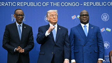 Donald Trump raises his fist while standing in between Rwandan President Paul Kagame and Democratic Republic of Congo President Felix Tshisekedi