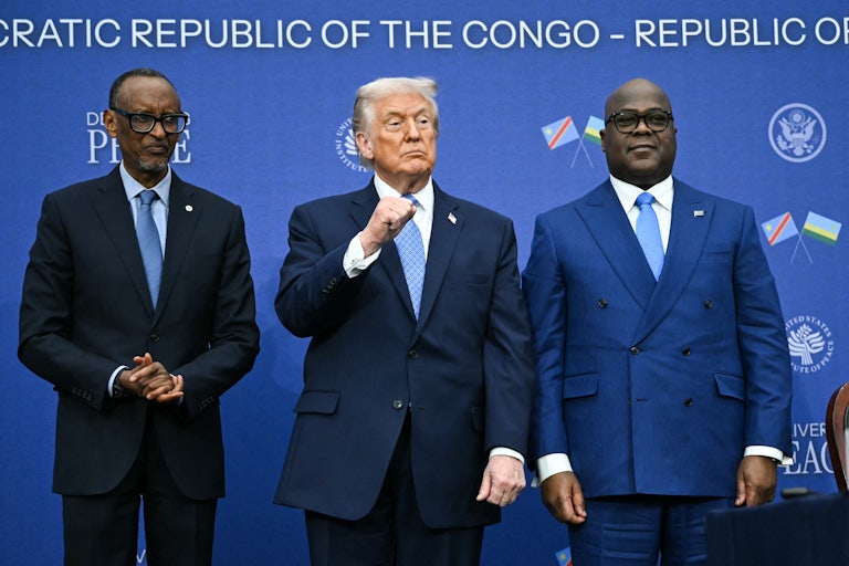 Donald Trump raises his fist while standing in between Rwandan President Paul Kagame and Democratic Republic of Congo President Felix Tshisekedi