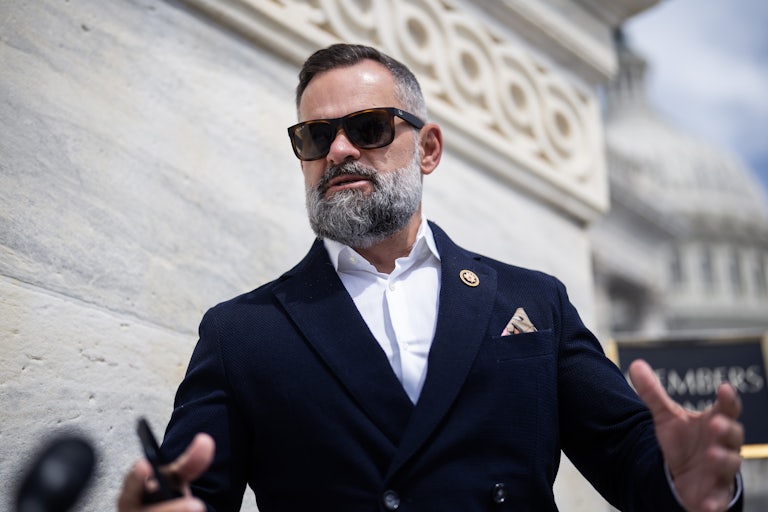Representative Cory Mills wears sunglasses and speaks outside the Capitol.
