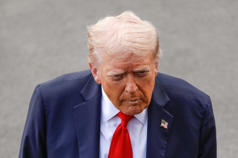Donald Trump purses his lips while standing outside the White House