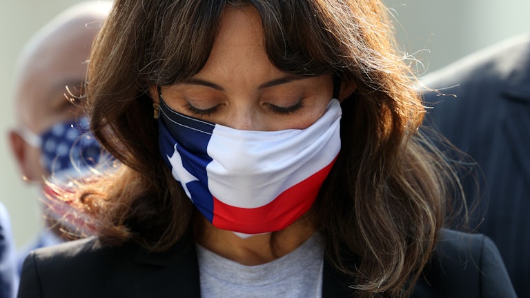 A close-up of a masked Texas State Representatives Gina Hinojosa, looking downwards.