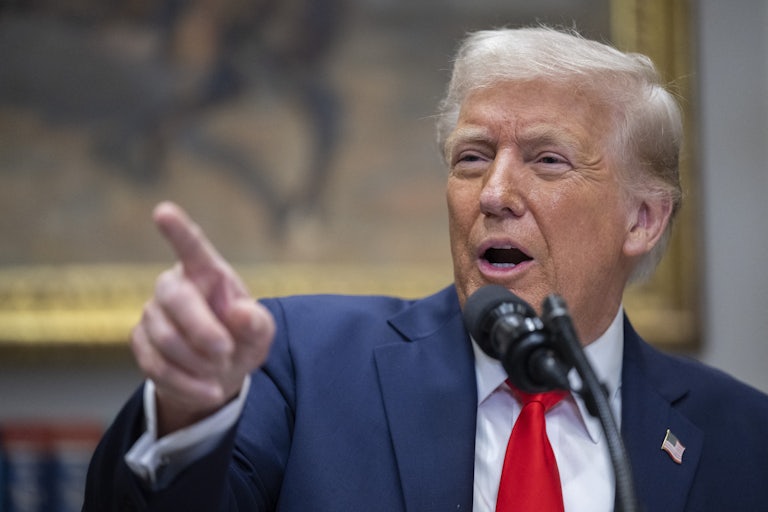 Donald Trump points while speaking at a podium during a press conference at the White House