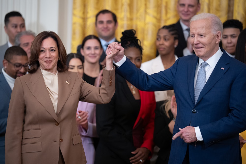 Joe Biden and Kamala Harris hold hands during a ceremony to celebrate the WNBA Champion Las Vegas Aces in the East Room of the White House.
