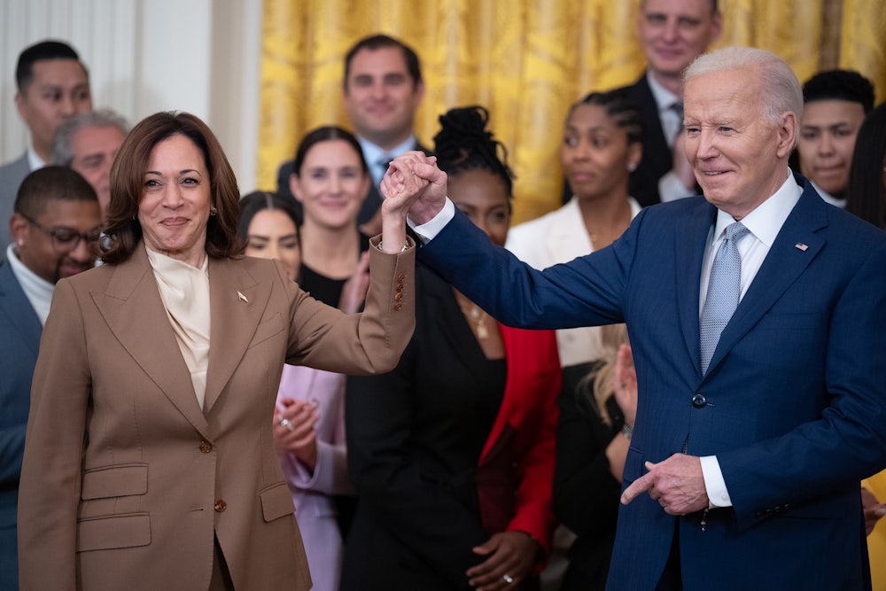Joe Biden and Kamala Harris hold hands during a ceremony to celebrate the WNBA Champion Las Vegas Aces in the East Room of the White House.