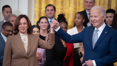 Joe Biden and Kamala Harris hold hands during a ceremony to celebrate the WNBA Champion Las Vegas Aces in the East Room of the White House.