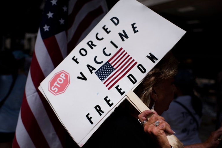 Anti-vaccine rally protesters hold signs outside of Houston Methodist Hospital in Houston, Texas.