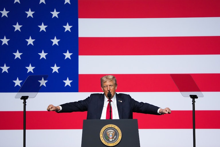 Donald Trump holds his fists out to the side while speaking to military leaders at Quantico