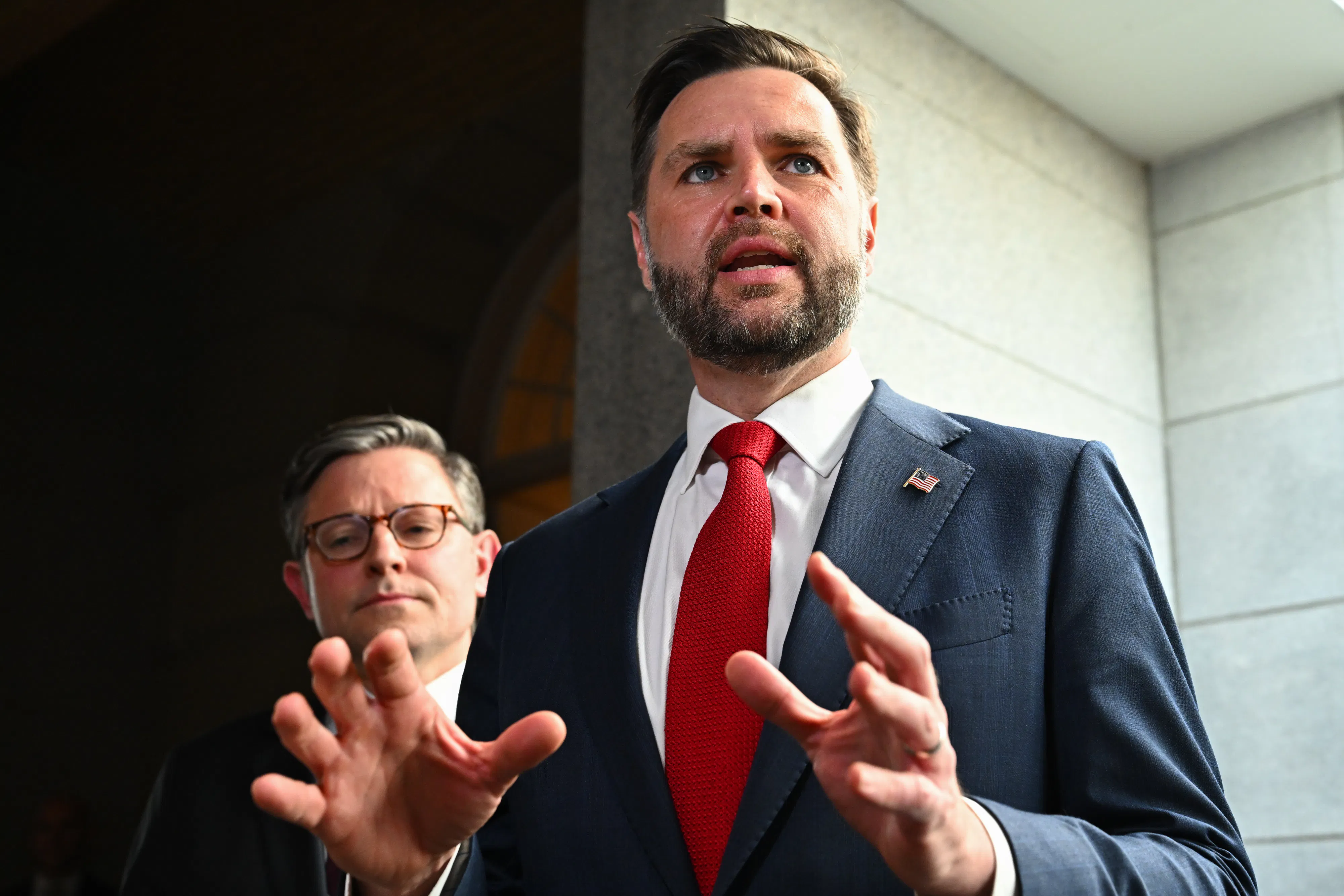 JD Vance speaks as House Speaker Mike Johnson stands in the background