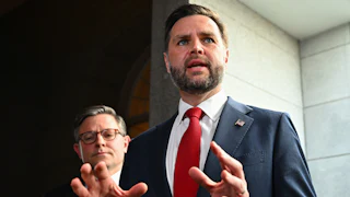 JD Vance speaks as House Speaker Mike Johnson stands in the background
