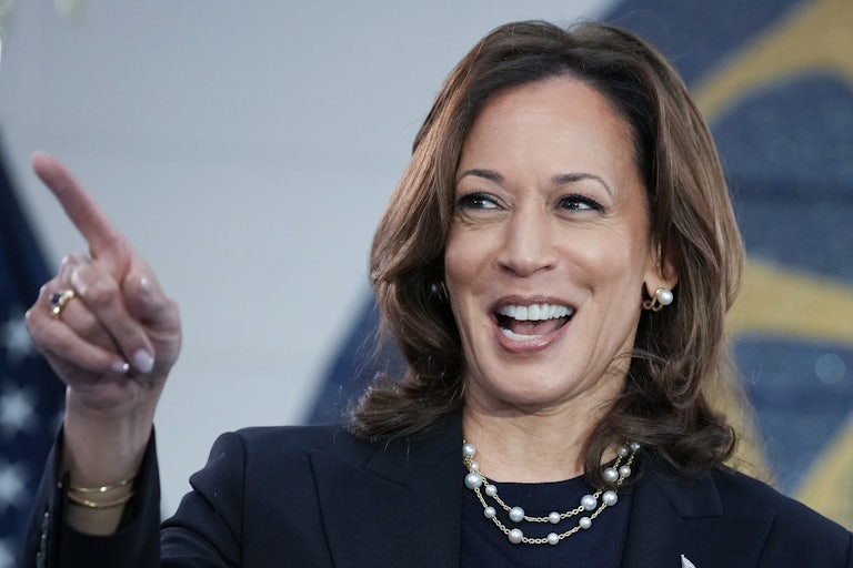 Kamala Harris smiles and points during a campaign rally