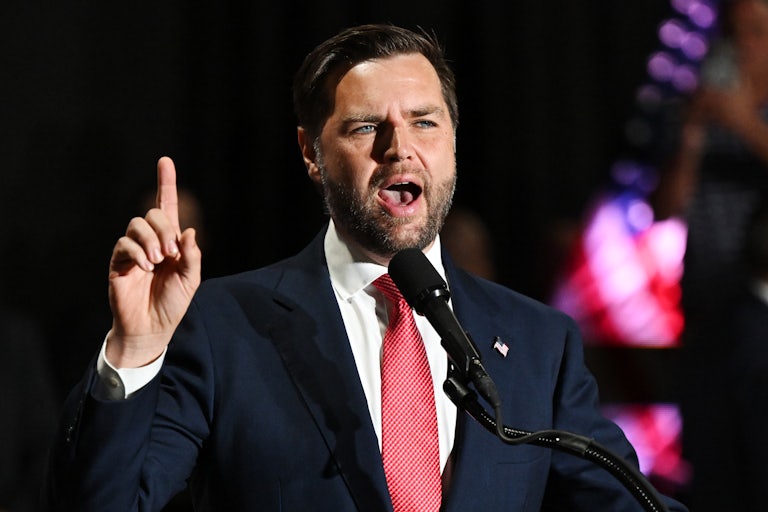 J.D. Vance speaks and raises his index finger in the air