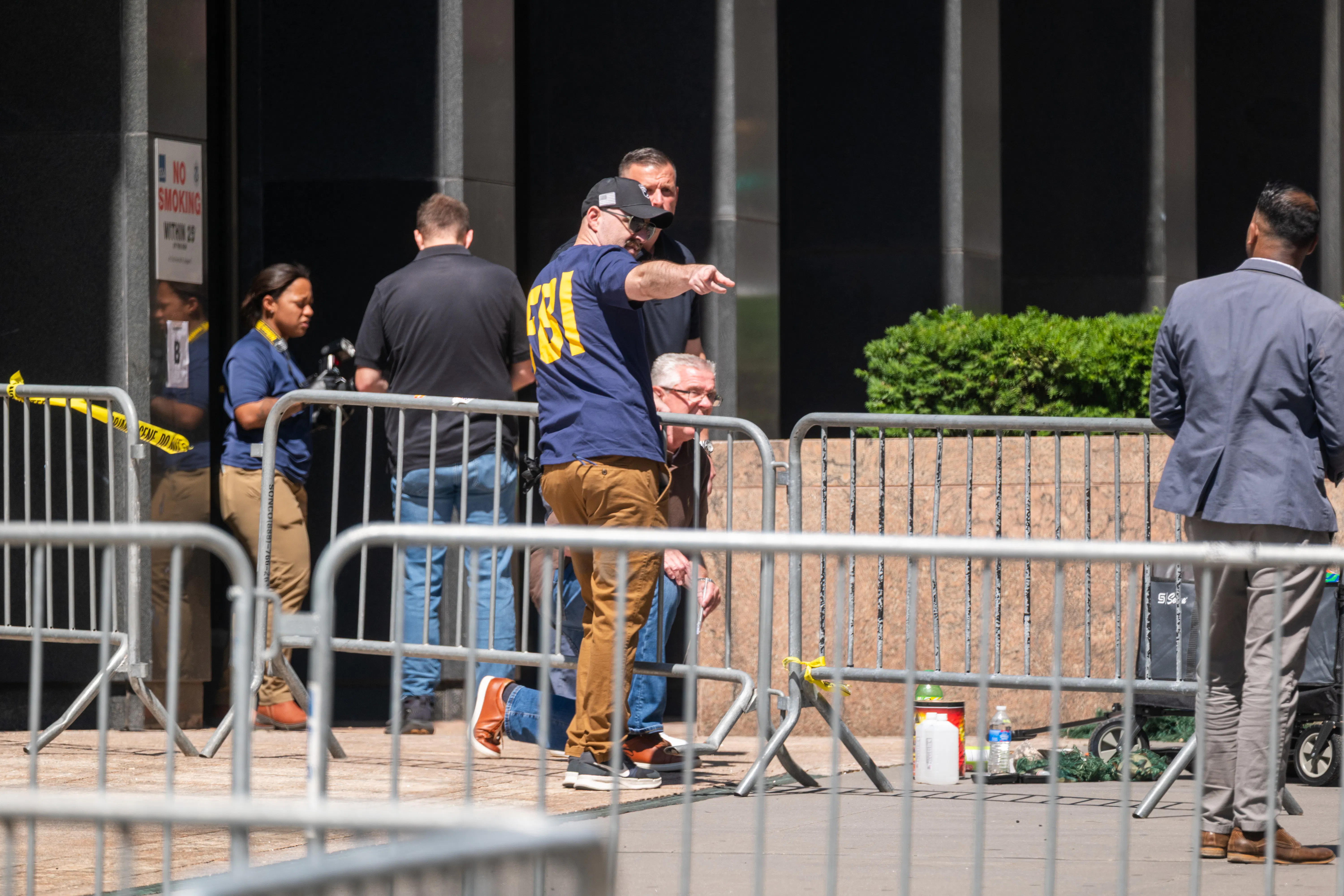 People from various agencies, including the FBI, gather outside of 26 Federal Plaza