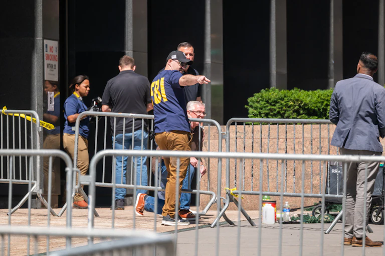People from various agencies, including the FBI, gather outside of 26 Federal Plaza.