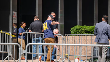 People from various agencies, including the FBI, gather outside of 26 Federal Plaza.