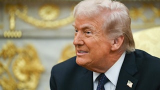 Donald Trump smiles while sitting in the Oval Office