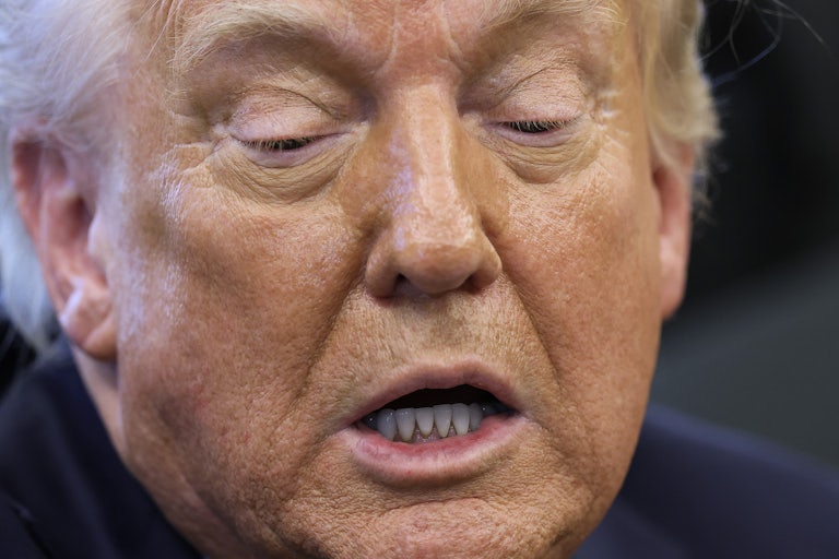 Donald Trump looks down while speaking to reporters in the Oval Office