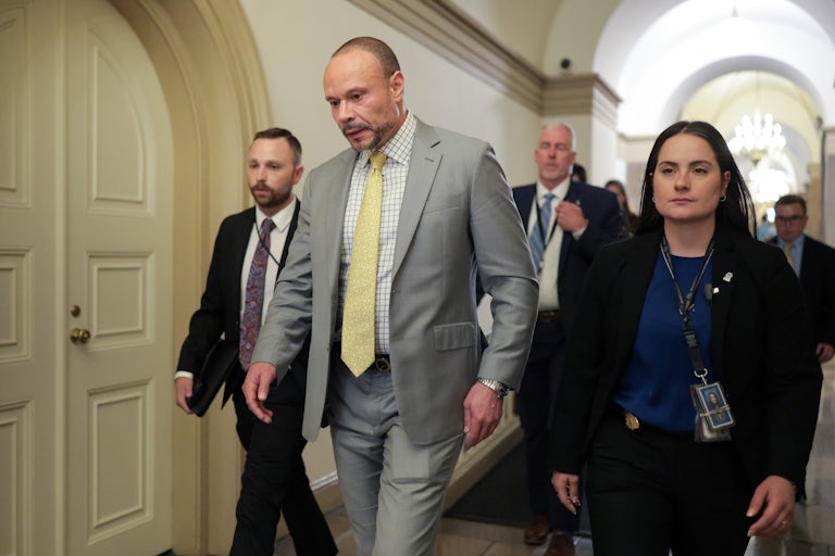 FBI Deputy Director Dan Bongino walks in the Capitol surrounded by others.