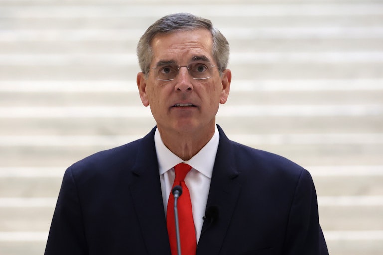 Secretary of State Brad Raffensperger speaks into microphone in the Georgia state Capitol