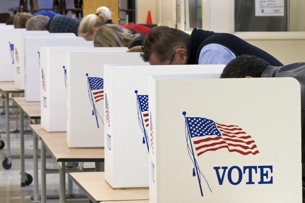 Several voters lean down to fill in their ballots on Election Day.