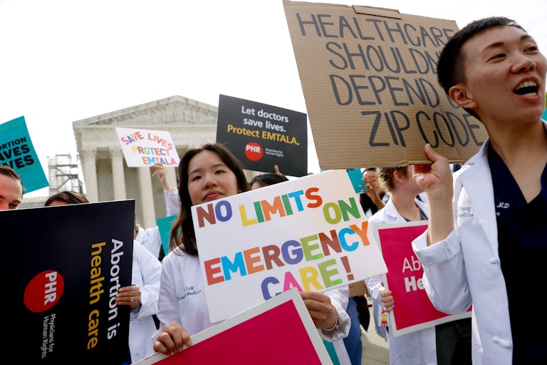 People hold pro-abortion protest signs outside the Supreme Court