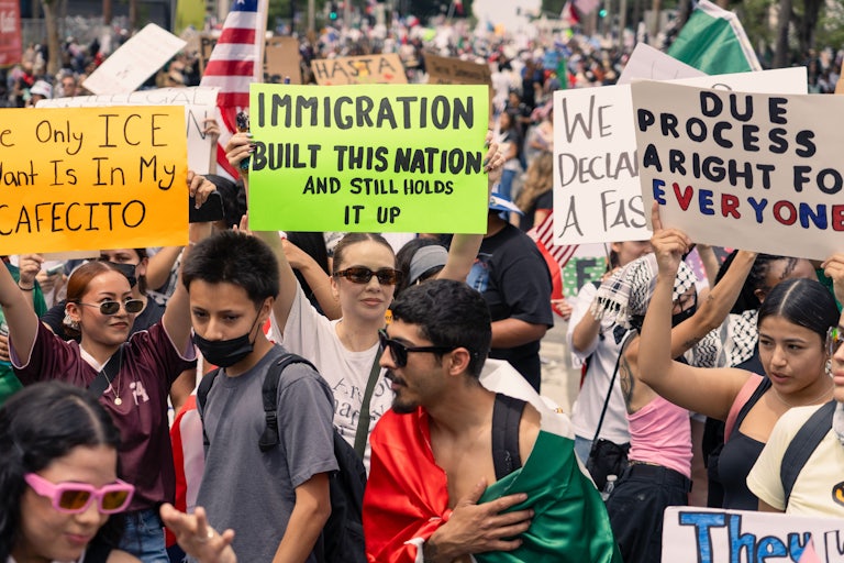 People gather for the No Kings protest in downtown Los Angeles, California. One sign reads "Immigration built this nation and still holds it up."