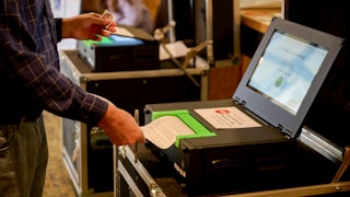 A man submits his ballot into a the voting machine.