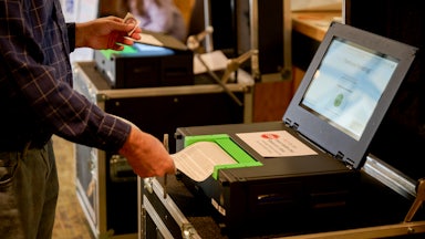 A man submits his ballot into a the voting machine.