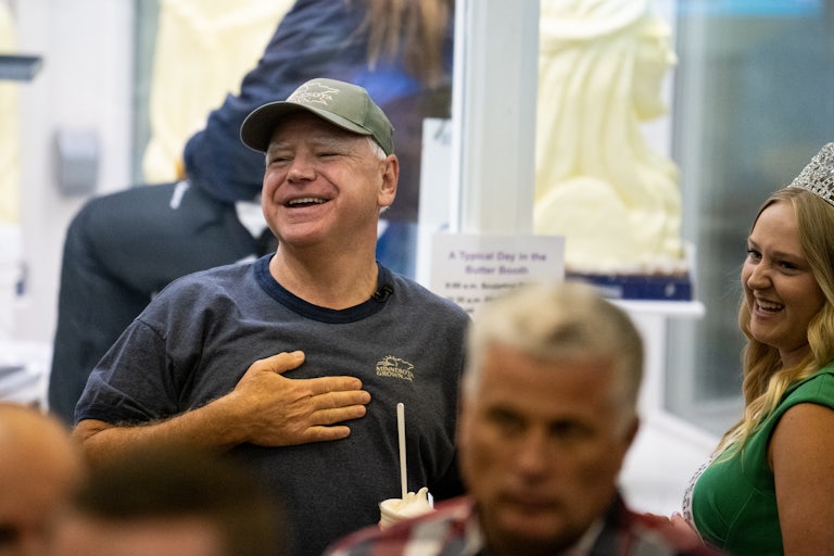 Tim Walz smiles and puts his hand on his chest