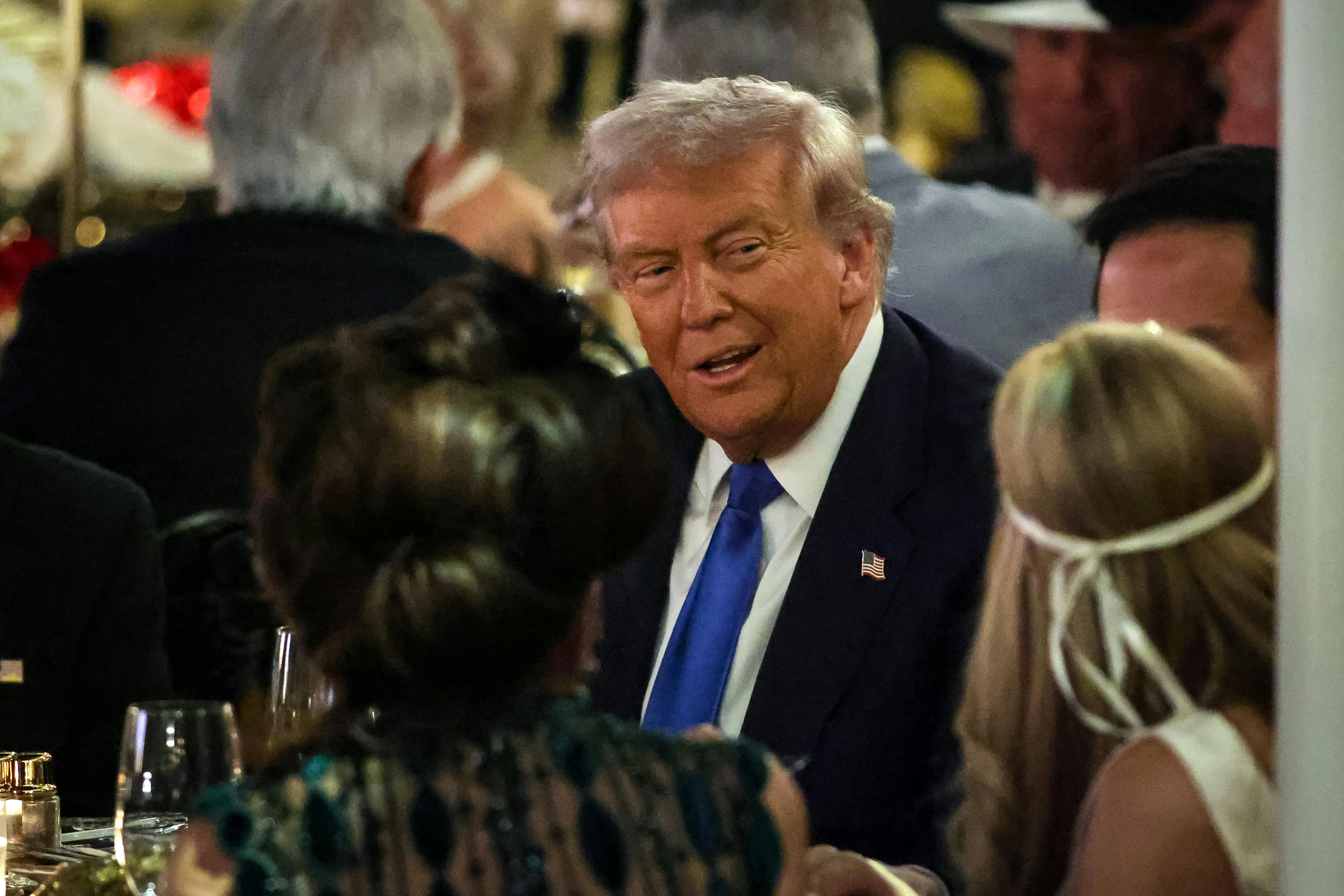Donald Trump talks with guests during a Halloween party at his Mar-a-Lago estate on October 31, 2025 at Palm Beach, Florida.