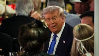 Donald Trump talks with guests during a Halloween party at his Mar-a-Lago estate on October 31, 2025 at Palm Beach, Florida.