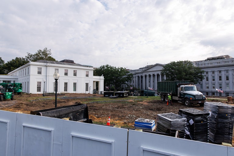 A construction truck and worker on the White House lawn work on Trump’s ballroom.
