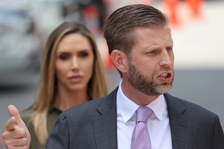 Eric Trump speaks. Lara Trump is in the background, out of focus.