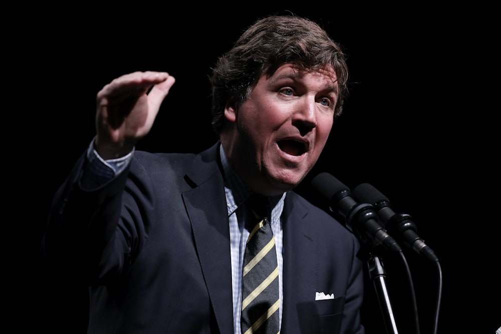 Tucker Carlson gestures while speaking
