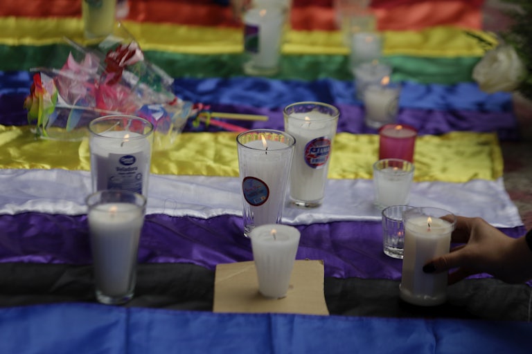 Candles are set on top of the nonbinary and pride flags